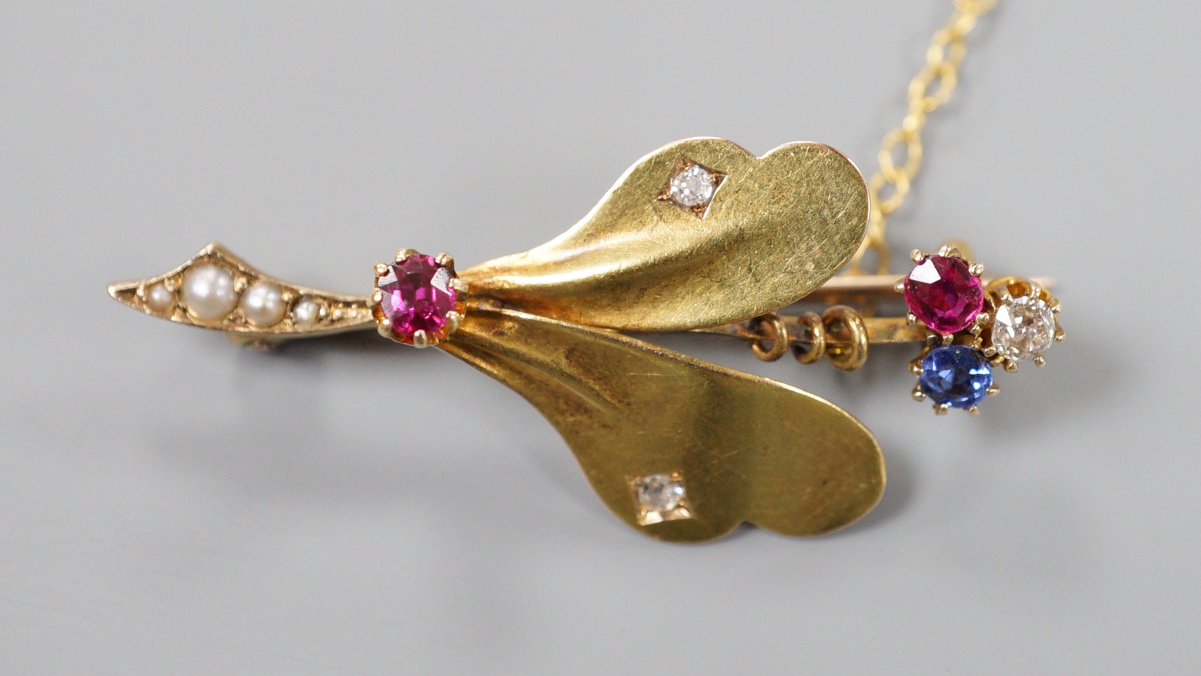 An Edwardian yellow metal, ruby sapphire, seed pearl and diamond set leaf brooch, 39mm, gross weight 4 grams.